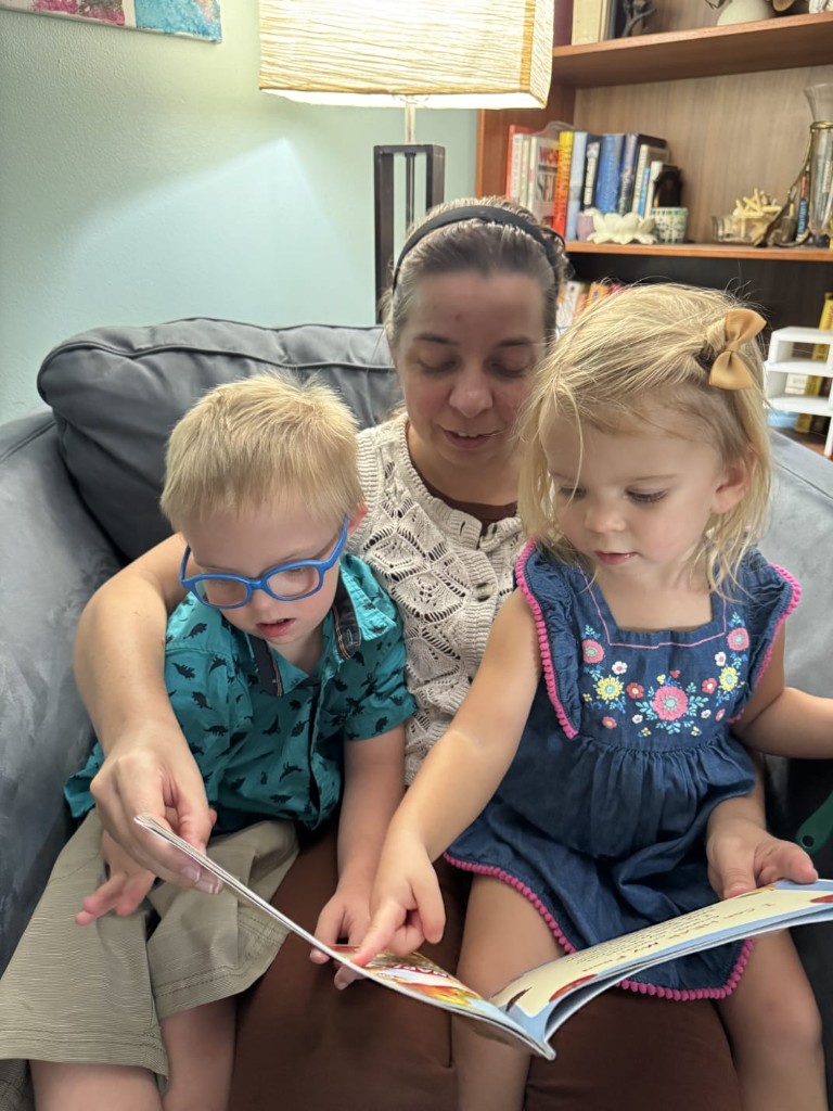 Suzanne reading with two children on the couch
